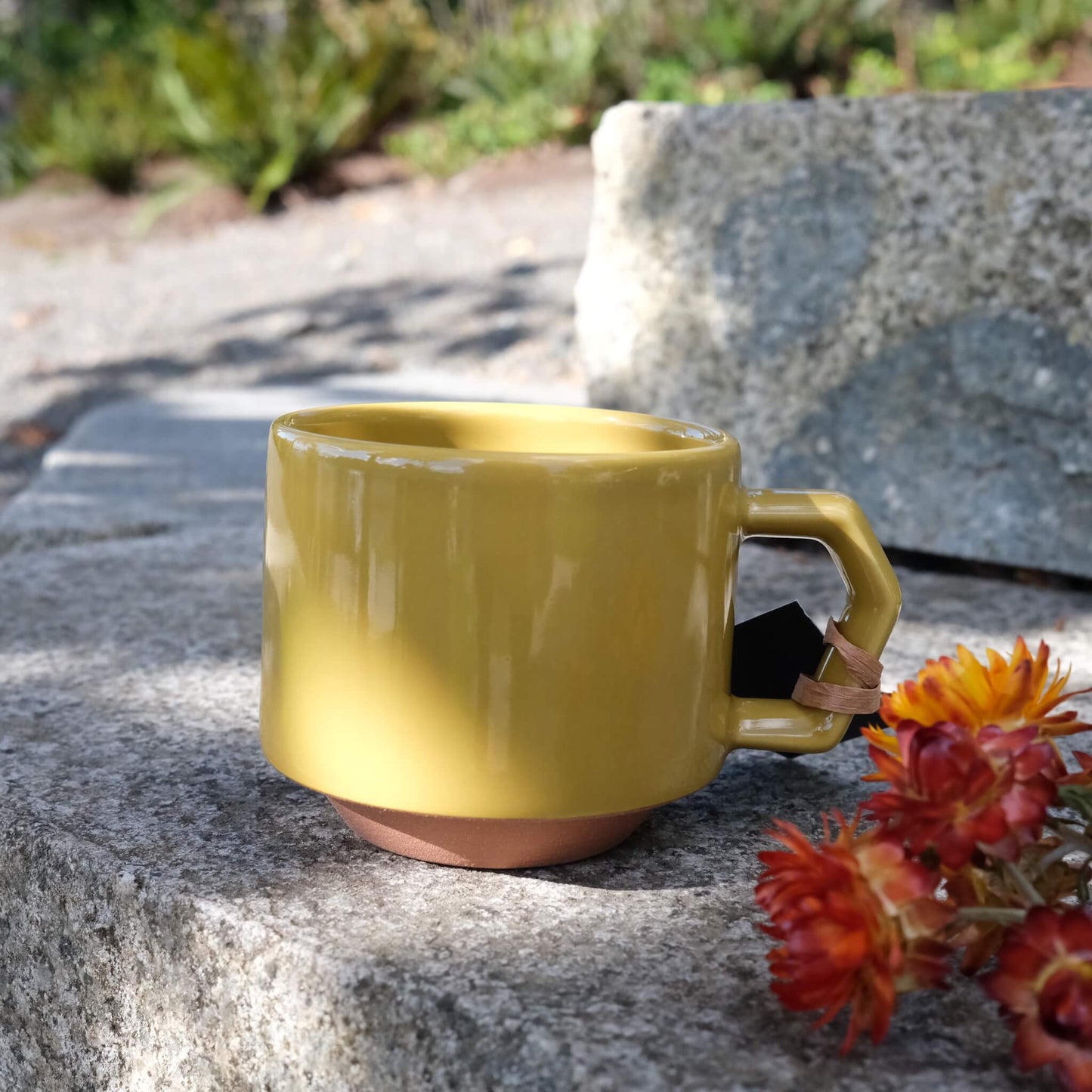 Side view of chips mug in mustard with stone background.