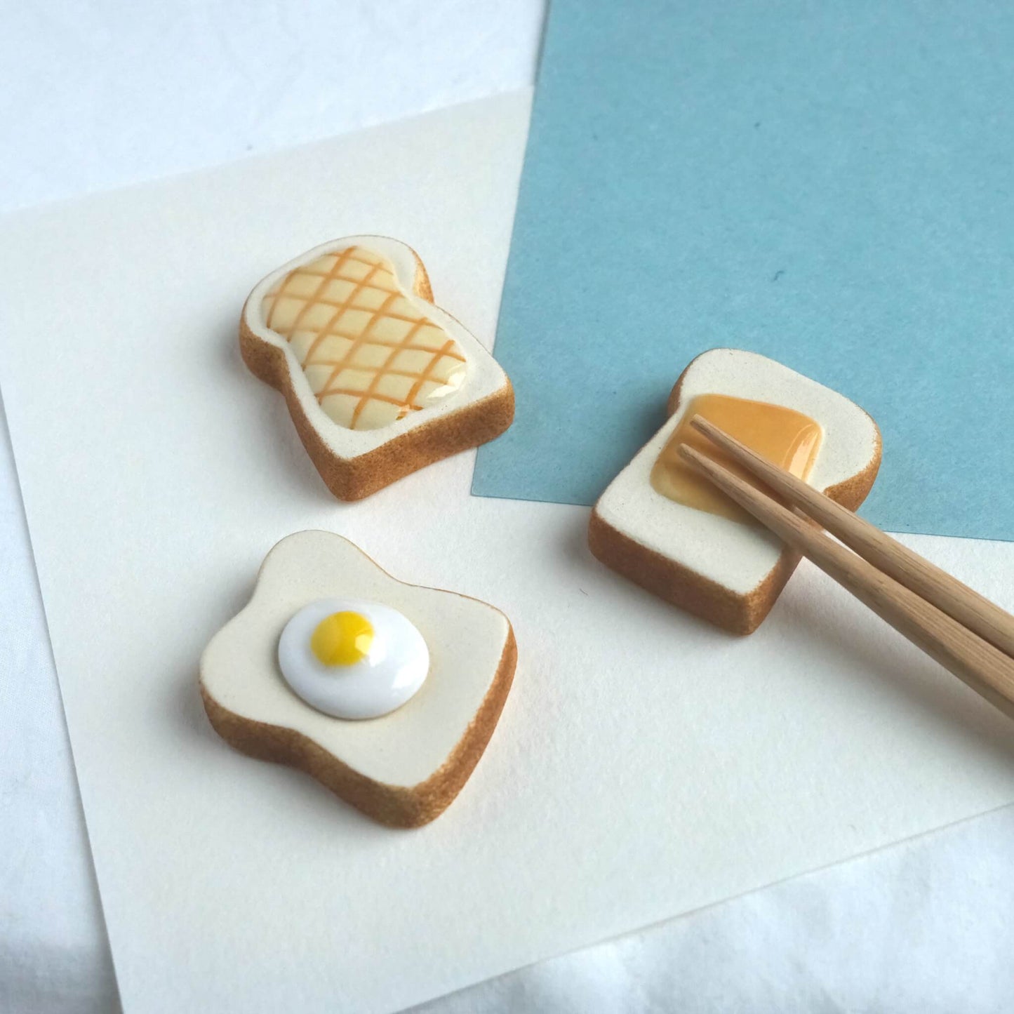 A collection of toasts- themed chopstick holders with chopsticks resting on it.